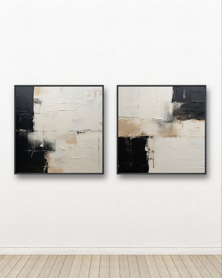 two black and white paintings hanging on the wall next to each other in an empty room