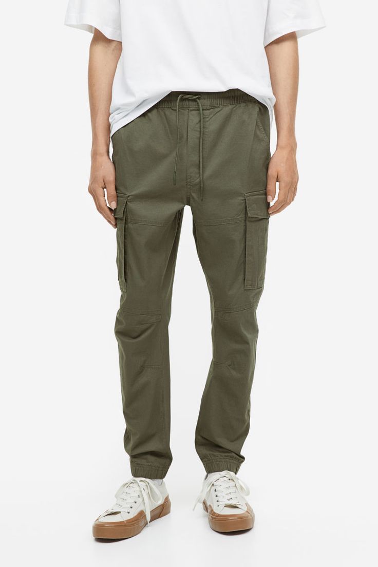 Joggers in woven cotton fabric. Waistband with drawstring and covered elastic. Diagonal side pockets  back pockets with flap and concealed snap fasteners  and leg pockets with flap and concealed snap fasteners. Tapered legs with seams and darts at knees and covered elastic at hems. Military Style Cotton Bottoms With Elastic Waistband, Cotton Utility Bottoms With Cargo Pockets, Utility Cotton Bottoms With Cargo Pockets, Military Style Cotton Parachute Pants With Multiple Pockets, Casual Cotton Cargo Jeans With Patch Pockets, Casual Cotton Parachute Pants With Multiple Pockets, Casual Cotton Cargo Pants With Pockets, Urban Style Cotton Cargo Pants With Side Pockets, Casual Workwear Cargo Pants With Elastic Waistband