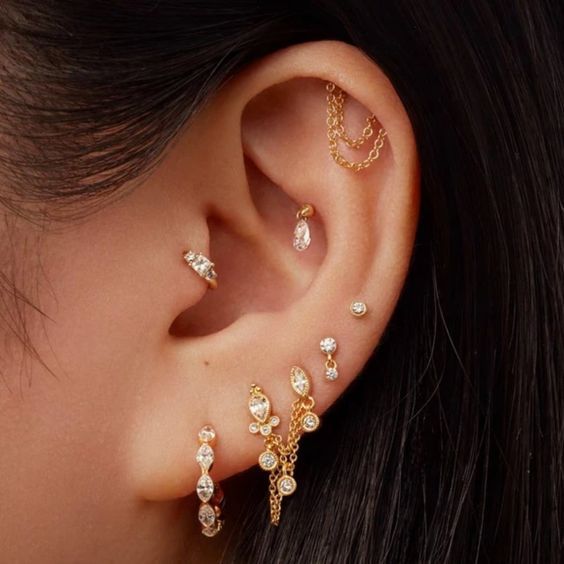 a close up of a person's ear with three different pieces of jewelry on it