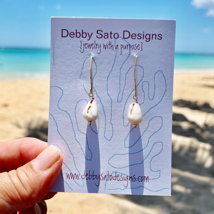 Perfect for the ocean lover in your life, these earrings feature petite cone shells. The length from the top of the earwire are about 1⅜" Pairs with our matches our Petite Cone Shell Necklace Available in Sterling Silver and Gold Fill The shells and beach glass we use are collected in Hawai`i. All our shells are never collected "live". These are natural Shells which means there will be variations in color, shape, and surface. A portion of all sales go to organizations that protect native Hawaiia Handmade Beachy Earrings As Gift, Handmade Beachy Earrings For Gift, Unique Drop Earrings For Beach, Unique Nickel-free Earrings For Beach, Handmade Ocean-inspired Pearl Earrings For Gift, Nickel-free Teardrop Earrings For Beach, Beach Teardrop Jewelry With Ear Wire, Teardrop Ear Wire Jewelry For Beach, Adjustable Shell Earrings With Ocean-inspired Style