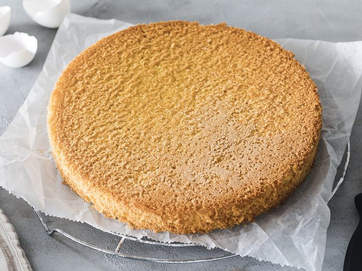 a round cake sitting on top of a piece of paper next to an egg knife