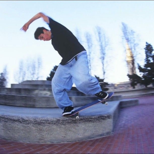 a man riding a skateboard up the side of a cement wall next to steps