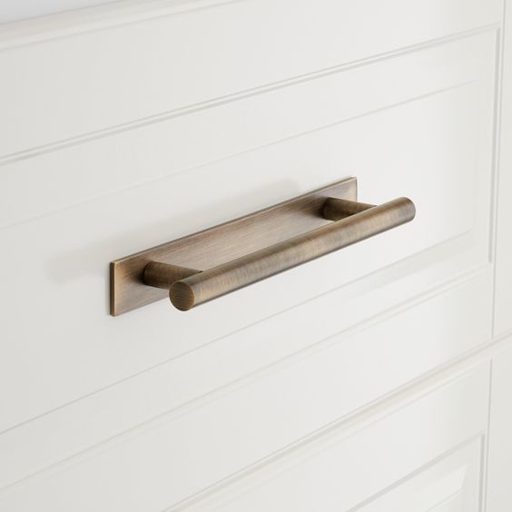 a close up of a door handle on a white cabinet