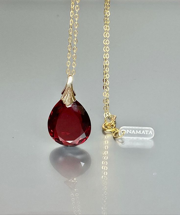 This pendant necklace showcases a gorgeous sparkly ruby pendant with a flawless, deep wine-red teardrop shape. The pendant exudes a captivating depth, reflecting light beautifully. It is gracefully strung on either a 14K gold-filled or Sterling Silver chain, offering versatility for layering with other necklaces or making a striking statement when worn alone. This necklace is truly a stunning beauty, radiating elegance and charm. Your description effectively conveys its allure and versatility. * Red Briolette Necklace For Formal Occasions, Red Gemstone Drop Necklace For Gift, Elegant Ruby Teardrop Pendant Necklace, Red Drop Necklace For Gift, Formal Drop Ruby Necklaces, Formal Ruby Drop Necklace, Fine Jewelry Ruby Drop Necklaces, Fine Jewelry Ruby Drop Necklace, Ruby Teardrop Pendant Necklace