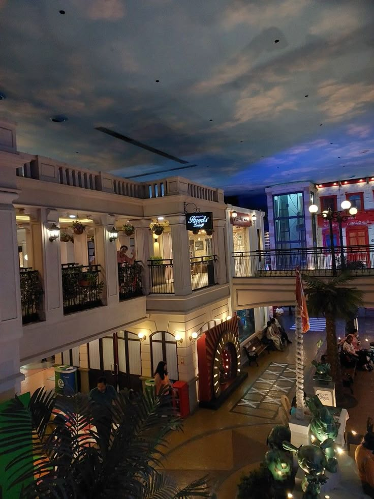 the inside of a building with people sitting at tables