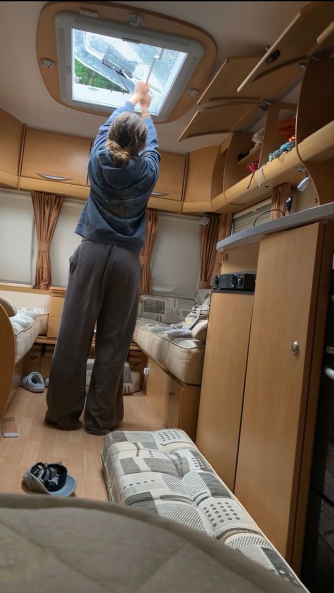 a person standing in the middle of a room with a skylight above them and other items on the floor