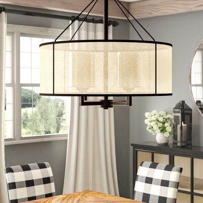 a chandelier hanging from the ceiling in a dining room with checkered chairs