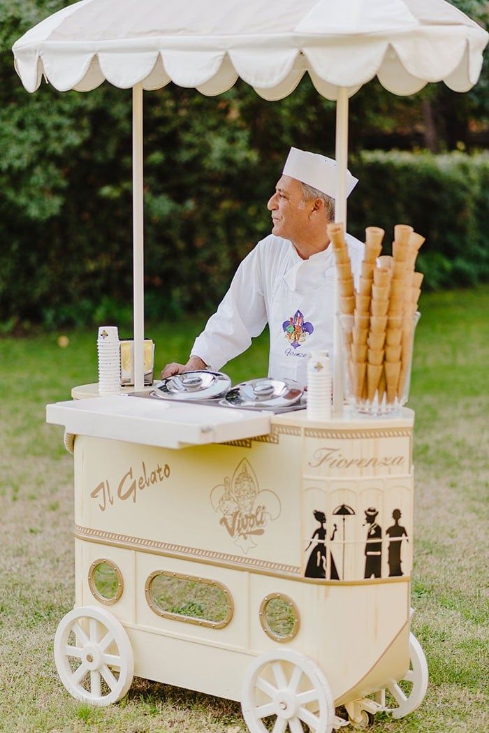 a man standing behind an ice cream cart