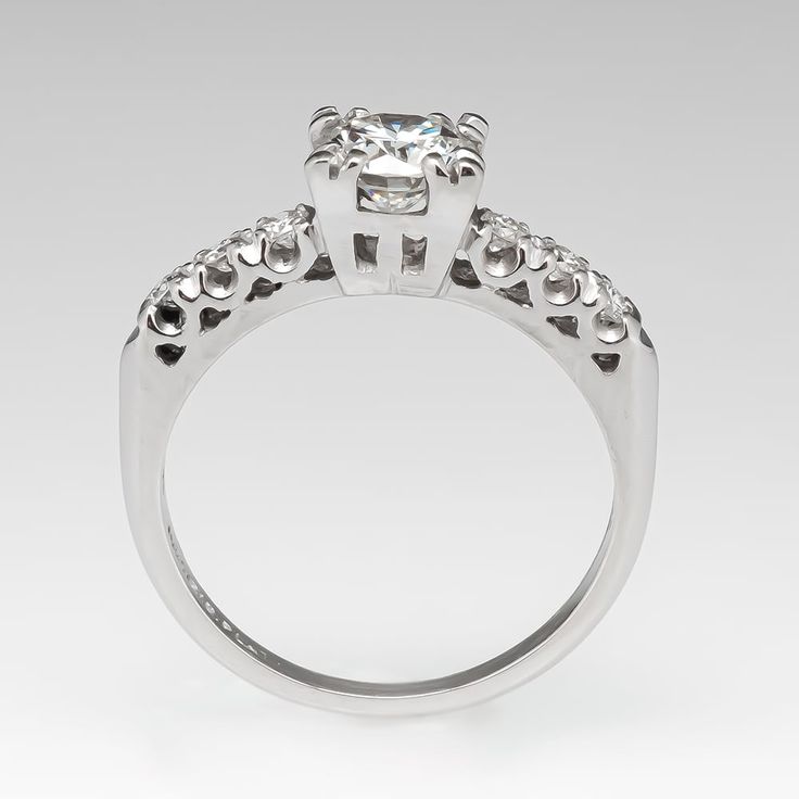 The vintage ring is centered with one (1) round brilliant cut diamond weighing 0.69 carat and set into a four-split prong head. The shoulders of the ring are each accented with three (3), prong set, round brilliant cut diamonds. The ring measures 6.2mm at the top, rises 5.8mm above the finger, tapering to 1.5mm wide and 1.2mm thick at the base of the shank. Classic Cut Diamond Wedding Ring With Prong Setting, Timeless Silver Diamond Ring With Prong Setting, Timeless Diamond Ring With Vvs Clarity And Classic Cut, Classic Diamond Ring With Tension Setting, Princess Cut, Classic Princess Cut Diamond Ring With Tension Setting, Diamond White Diamond Ring With Prong Setting, Timeless Vvs Clarity Round Cut Diamond Ring, Classic Diamond White Diamond Ring With Tension Setting, Classic Diamond Ring With Lab Grown Diamond Accents