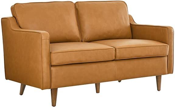 a tan leather couch sitting on top of a white floor next to a wooden frame