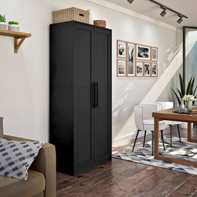 a living room filled with furniture and a tall black cabinet next to a dining table