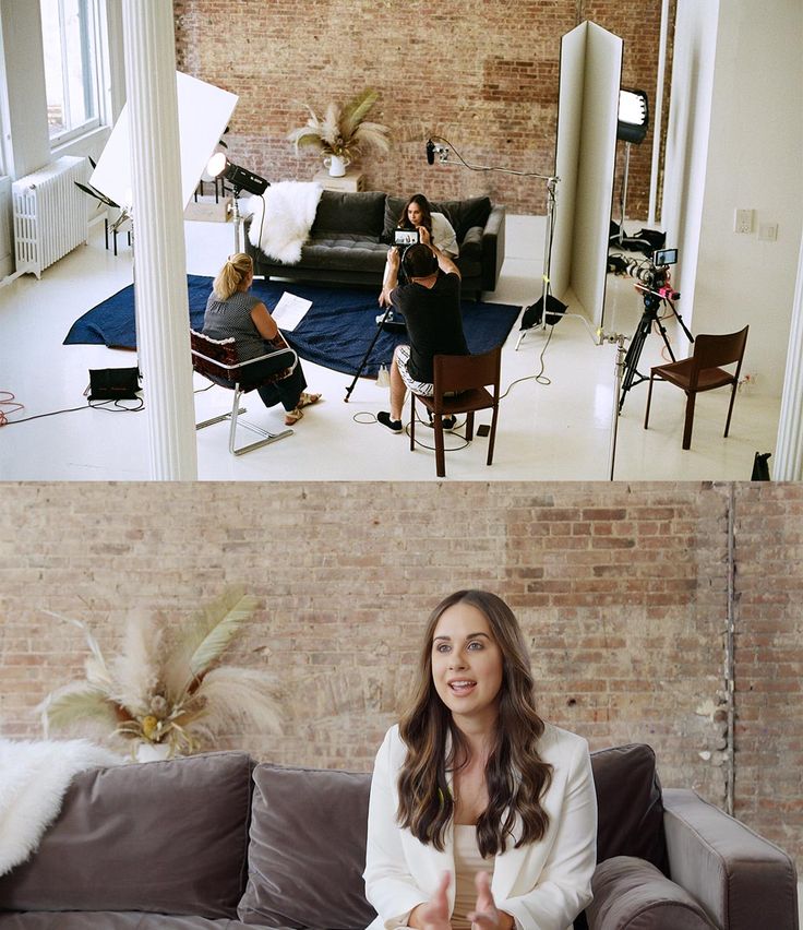 two women sitting on a couch in front of a brick wall and another woman standing behind the couch