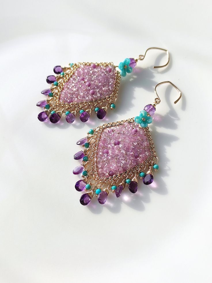 These are some natural pink-purple sapphires, and I weaving them together with gold wire, making this gentle pink-purple even stronger. matched with equally bright amethyst, embellished with some turquoise and blue lampwork flowers. The metal part is 14k gold-filled, which will not fade or cause skin discomfort. 🌸The delivery time to Most regions of North America, Australia and Europe is usually about 10-15 days. Buyers from Brazil, South Korea, and Indonesia, please provide me with your tax number through messages or notes for smooth shipment. Thank you. 🌸Please let me know your phone number when you place an order. It will be used for shipping label only. 🌸I will pack the goods very carefully and beautifully. They can be used as gifts. 🌸Thank you for liking my work. If you have any q Purple Gemstone Accented Drop Earrings, Purple Drop Earrings With Gemstone Accents, Bohemian Amethyst Chandelier Earrings Gift, Bohemian Pink Jewelry With Gemstone Accents, Purple Gemstone Accented Dangle Earrings, Purple Gemstone Dangle Earrings, Purple Dangle Earrings With Gemstone Accents, Unique Purple Jeweled Dangle Jewelry, Handmade Amethyst Teardrop Chandelier Earrings