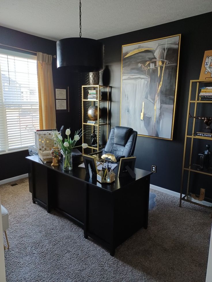 Home office painted in black, decorated with gold shelves, and gold accents. Black And Gold Home Office Ideas, Black Decor Office, Gold White Black Office, Male Desk Decor Office Ideas, His Office Decor, Grey Black Gold Dining Room, Boujee Home Office, Black And White Office Decor Ideas, Masculine Glam Office