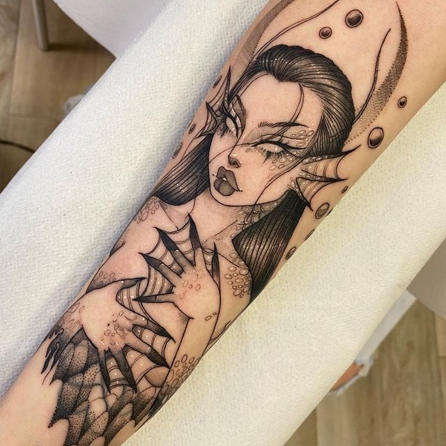 a woman's arm with an artistic tattoo design