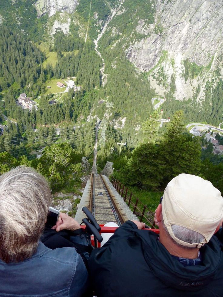 two people sitting on a bench looking at the mountains