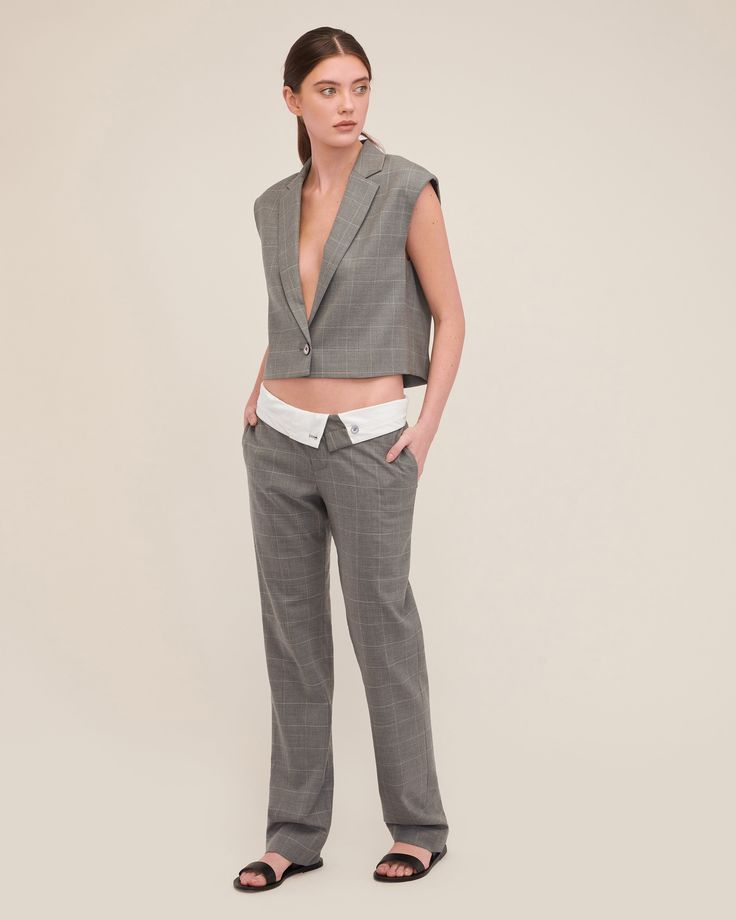 Cut in a smooth luxurious wool, the Dana is structured yet lightweight and features a daring deep V neckline. This vest effortlessly transitions from desk to dinner, ensuring you move through your day with confidence. Style the Dana with the Leo Foldover Waist Trouser for a hook up that embodies modern suiting with a touch of downtown edge. Easy fit Deep V neck Notch collar with traditional blazer details Single breasted, button closure Sleeveless Dropped armholes Light shoulder pad Fully lined Fitted V-neck Blazer For Office Wear, Fitted V-neck Vest For Office, Tailored Blazer With Vest For Office, Chic Fitted Sweater Vest For Work, Semi-formal Fitted V-neck Vest, Elegant V-neck Vest For Office Wear, Fitted V-neck Vest For Semi-formal Occasions, Fitted Sleeveless Blazer For Office, Tailored V-neck Blazer For Workwear