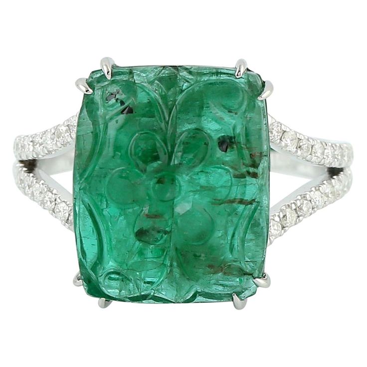 This ring has been meticulously crafted from 18-karat gold. It is hand set in 8.16 carats carved emerald & .24 carats of diamonds. The ring is a size 7 and may be resized to larger or smaller upon request. FOLLOW MEGHNA JEWELS storefront to view the latest collection & exclusive pieces. Meghna Jewels is proudly rated as a Top Seller on 1stDibs with 5 star customer reviews. All items manufactured by us are handmade and can be customized or redesigned. Composition Size-US-7 Total Weight-5.525 Gold Oval Emerald Rings With Pave Setting, Oval Emerald Ring With Single Cut Diamonds, Green Platinum Ring With Pavé Setting, Oval Emerald Ring With Pave Setting In Platinum, Green Platinum Rings With Pave Setting, Luxury Emerald Jewelry With Single Cut Diamonds, Luxury Emerald Gemstones With Prong Setting, Green Pave Setting Rings For Formal Occasions, Luxury Emerald Cut Gemstone With 17 Jewels