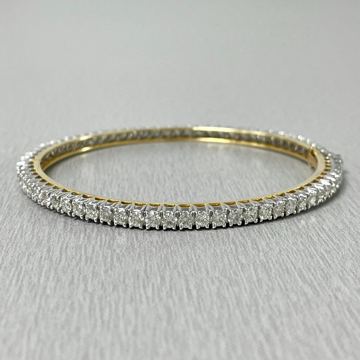 The Classic & Evergreen Bangle that delicately accentuates the wrist. This bangle is open-able for ease of putting on and taking off. Total Diamond Weight: 5.03 ct No. of Diamonds: 72 Average Diamond Weight: 0.07 ct Diamond Color: H Diamond Clarity: VVS - VS (Very Very Slightly Included - Very Slightly Included) Metal: 14K White & Yellow Gold Metal Wt: 12.20 gms Setting: Prong Set Inner Diameter: 2.25 Inches (5.72 cms) Openable with double lock system for added security Formal Bangle With Single Cut Diamonds, Classic Wedding Bangle With Vvs Clarity, Classic Round Bangle With Diamond Accents, Hand Set Diamond Bangle In Fine Jewelry Style, Classic Hand Set Diamond White Bangle, Classic Diamond White Bangle Hand Set, Vvs Clarity Diamond Bangle For Wedding, Timeless Cubic Zirconia Bangle With Diamond Cut, Anniversary Tennis Bracelet With Single Cut Diamonds