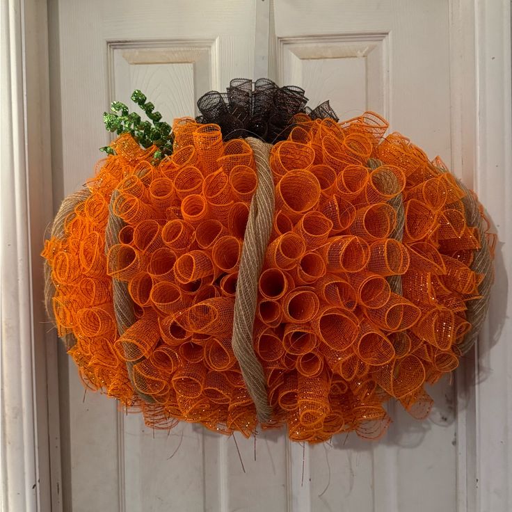 an orange wreath hanging on the front door