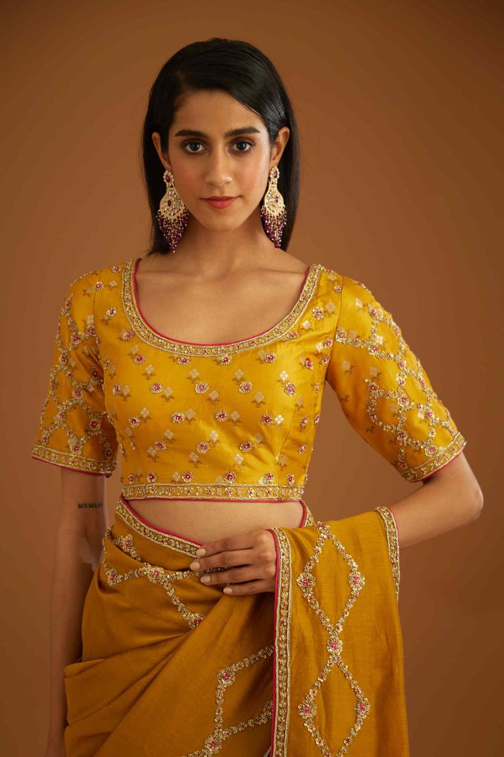 Editor's Note A mustard yellow zardozi embroidered dupion silk sari and blouse would be a stunning choice for a traditional event or wedding. The rich and vibrant color paired with intricate zardozi embroidery would make for a gorgeous and elegant ensemble. Color: Mustard yellow Fabric: Dupion silk & chanderi Embroidery details: Zardozi embroidery Components: Sari & blouse Sari length: 6 meters, sari width: 46" inches Occasion: Festive and Wedding Guest Disclaimer: Product color may slightly var Mustard Zari Work Sets For Wedding, Fitted Yellow Embroidered Fabric With Zari Work, Elegant Yellow Embroidered Saree Fabric, Yellow Zari Work Embroidered Semi-stitched Fabric, Mustard Saree, Blouse Sari, Blouse Yoke, Zardozi Embroidery, Personal Shopping Service