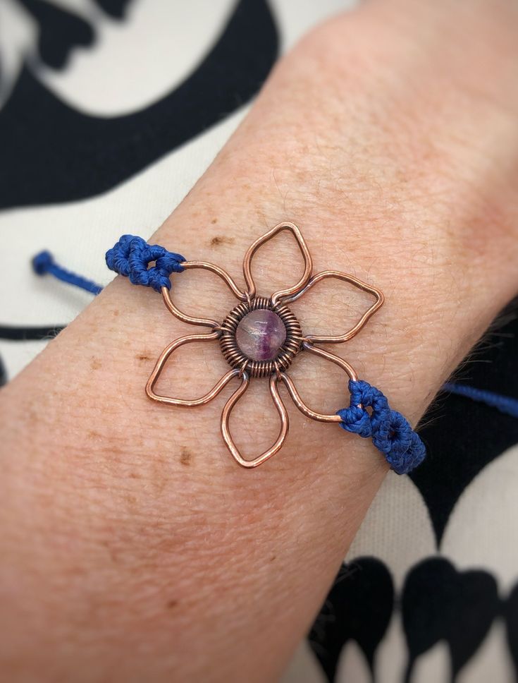 This cute hand shaped flower is is embellished with a beautiful Fluorite stone.  The Copper has been antiqued (oxidized and blackened) then polished for a more rustic look. Copper will naturally darken over time but a jewelry polishing cloth can help to bring back some of its shine.  The bracelet is adjustable and made with lightly waxed polyester cord making it water resistant. This beautiful piece of jewelry would be perfect for you or a gift for that special someone! ❤️ MATERIALS USED      ▪️ Adjustable Flower Shaped Gemstone Jewelry, Bohemian Bracelets With Flower Charm For Jewelry Making, Handmade Spiritual Flower Beaded Bracelets, Adjustable Flower-shaped Spiritual Bracelets, Adjustable Spiritual Flower Bracelet, Bohemian Wire Wrapped Flower Jewelry, Bohemian Flower-shaped Wire Wrapped Jewelry, Unique Adjustable Flower Jewelry, Purple Hippie Jewelry For Gift