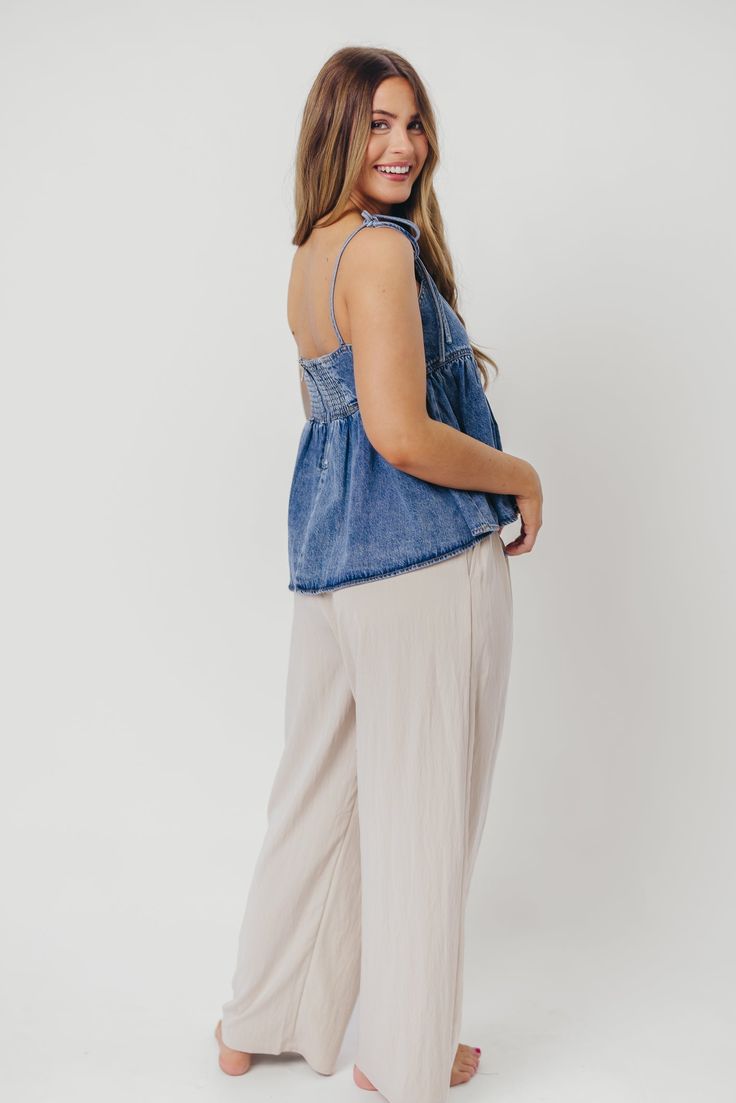 This elegant little top features adjustable tie shoulder straps, with a scallop neckline and empire-waisted silhouette. The Ricci Top pairs beautifully with your favorite denim or white trousers. Also available in Off-White/Blue Colorway. FIT: Runs true to size - cropped. MATERIAL: 100% Cotton. Hand wash cold, do not bleach, line dry. GARMENT DETAILS: Lightweight cotton denim babydoll top with scalloped neckline and adjustable tie shoulder straps. Features an empire waist, smocked back panel, an Denim Spaghetti Straps Tops For Summer, Denim Spaghetti Strap Tops For Summer, Denim Tops With Spaghetti Straps For Summer, Summer Denim Spaghetti Strap Tops, Casual Denim Spaghetti Strap Top, Casual Denim Top With Spaghetti Straps, Spring Cotton Cami Bottoms, Spring Casual Tie Back Bottoms, Casual Spring Bottoms With Tie Back