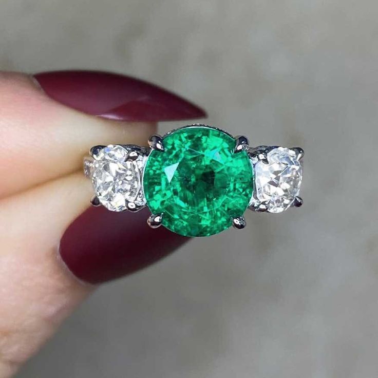 This item has just been reserved by another customer. Please contact us to be notified if it becomes available.  This stunning three-stone ring showcases a round, genuine green emerald weighing approximately 2.48 carats. displaying exceptional color intensity. The central gem is accompanied by two old European cut diamonds, totaling 1.29 carats in I color and VS2 clarity, This platinum ring is adorned with micro-pave diamonds both along the under-gallery and on the shoulders The emerald at the c Diamond Ring Platinum, European Cut Diamond Ring, Estate Diamond Jewelry, Green Emerald Ring, Art Deco Diamond Rings, European Cut Diamonds, Art Deco Diamond, Platinum Ring, Unique Engagement