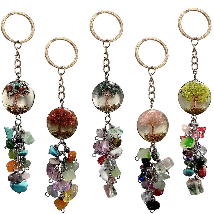 four different types of key chains with charms attached to them, each one has a tree on it