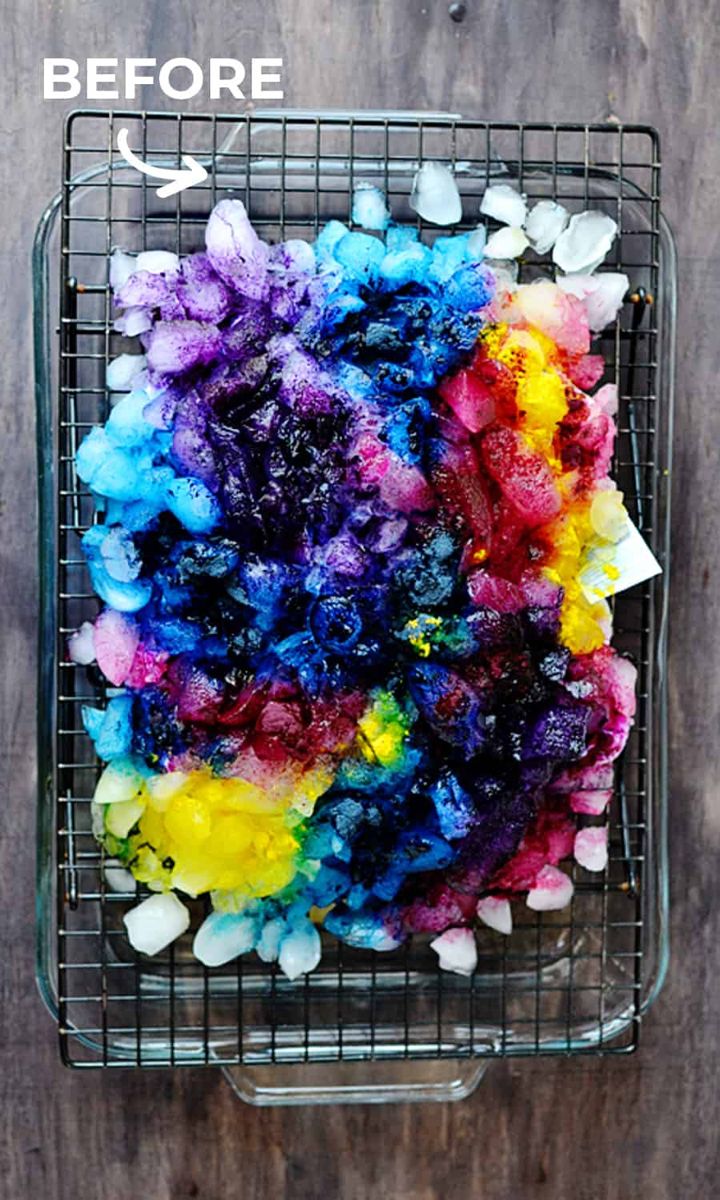 a metal basket filled with lots of different colored dyes on top of a wooden table