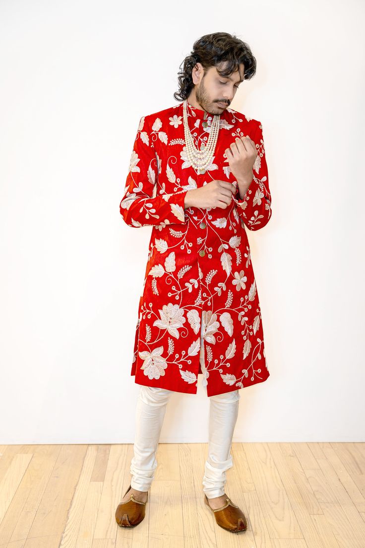 Make a lasting impression in our BRIJ Red and White Wedding Sherwani. Made with a beautiful embroidered dupioni, this sherwani features a stunning white and gold floral pattern for a modern twist on a classic Indian groom look. The perfect choice for a sophisticated but bold Indian groom. Details Thread and Sequin Embroidered 100% Polyester Dupioni Lined in Crepe-back Satin Dry Clean Only Item #102601-24-04 Made in NYC - Ethically designed + produced in New York City Elegant Sherwani With Floral Embroidery, Festive Bandhgala With Floral Embroidery For Wedding, Festive Floral Embroidered Bandhgala For Wedding, Formal Sherwani With Floral Embroidery For Diwali, Traditional Sherwani With Floral Embroidery For Festivals, Bollywood Style Sherwani With Floral Embroidery For Festivals, Bollywood Style Floral Embroidered Sherwani For Festivals, Traditional Sherwani With Floral Embroidery, Bollywood Straight Kurta Sherwani With Floral Embroidery