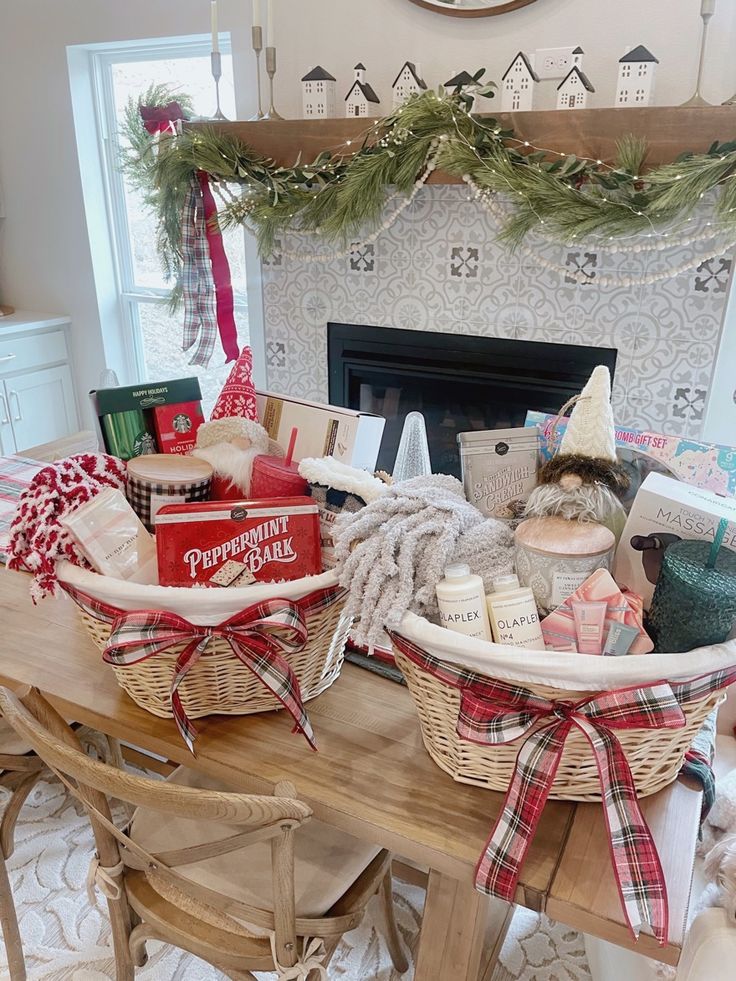 two baskets filled with gifts sitting on top of a table next to a fire place