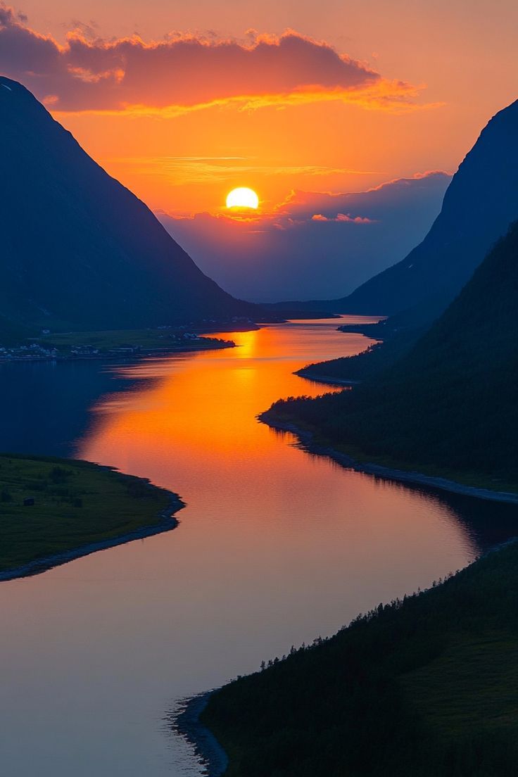 the sun is setting over some mountains and water