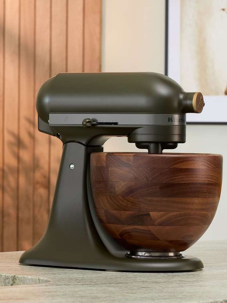 a brown wooden bowl on top of a black stand mixer