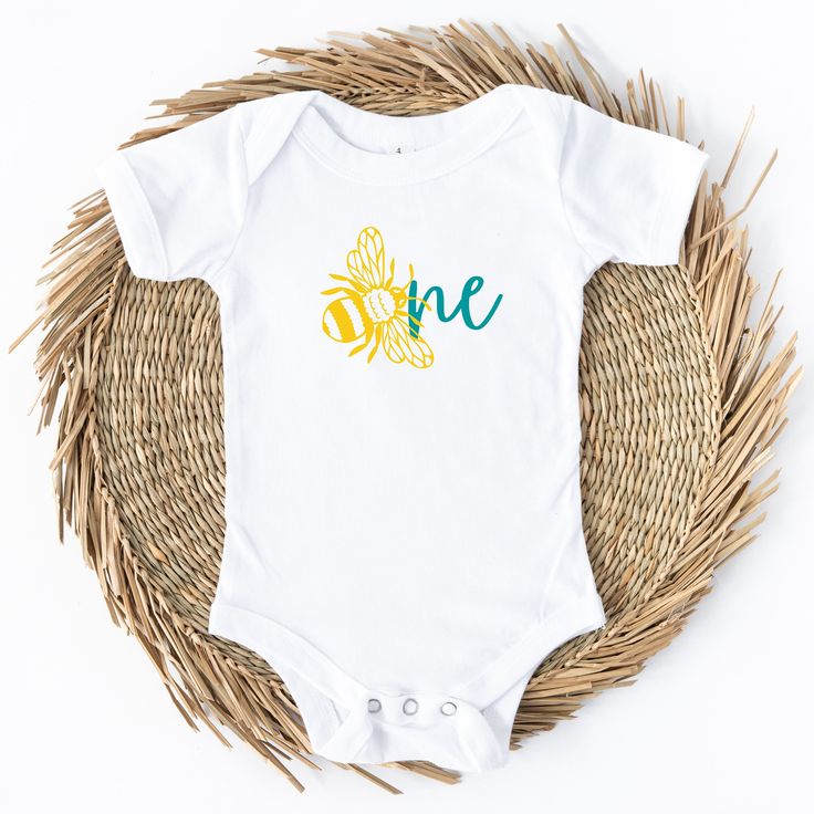 Introducing the Bee Day ONE Baby Birthday Bodysuit, a delightful and adorable outfit designed to make your little one's first birthday extra special. Crafted with love, this bodysuit captures the joy and sweetness of your baby's milestone celebration. Made from soft, breathable cotton fabric, the Bee Day ONE bodysuit ensures utmost comfort for your precious one. Its gentle and stretchy material is perfect for your baby's delicate skin, allowing them to move and play freely throughout the day. Th Fitted Onesie For First Birthday, Family Matching Summer Birthday Onesie, Summer Family Matching Birthday Onesie, Family Matching Onesie For Birthday In Summer, Playful Short Sleeve Bodysuit For First Birthday, First Birthday Spring Cotton Bodysuit, Spring Cotton Bodysuit For First Birthday, Family Matching Short Sleeve Bodysuit For First Birthday, Summer Birthday Onesie With Short Sleeves