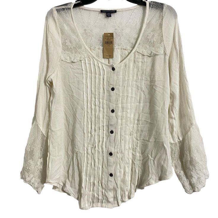 Add A Touch Of Bohemian Style To Your Wardrobe With This Beautiful American Eagle Outfitters Blouse. Featuring A Scoop Neckline, Button Closure, And Long Bell Sleeves, This Blouse Is Perfect For Any Occasion. The Pleated Accents And White Lace Pattern Add A Touch Of Elegance To The Blouse, Making It A Versatile Addition To Your Wardrobe. This Blouse Is Perfect For Women Who Love To Add A Touch Of Style To Their Outfits. The Size S Blouse Is Made In India And Is Perfect For Regular-Sized Women. W Bohemian Cream Top With Buttons, Bohemian Cream Tops With Buttons, Bohemian Spring Tops With Buttons, White Bohemian Blouse With Button Closure, Casual Button-up Peasant Top For Summer, Fall Peasant Top With Lace Trim, Bohemian Spring Blouse With Buttons, Spring Bohemian Blouse With Buttons, Bohemian Blouse With Button Closure For Day Out