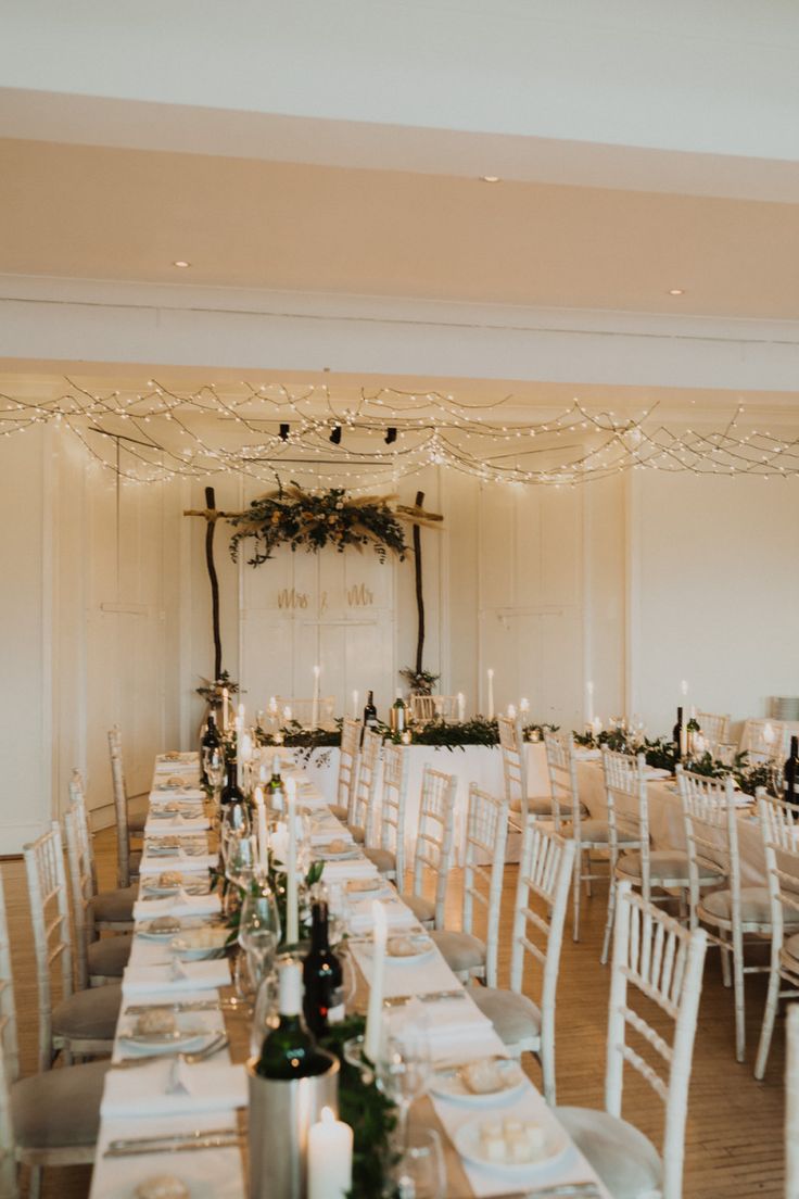 a long table is set with place settings and candles for an elegant wedding reception at the inn