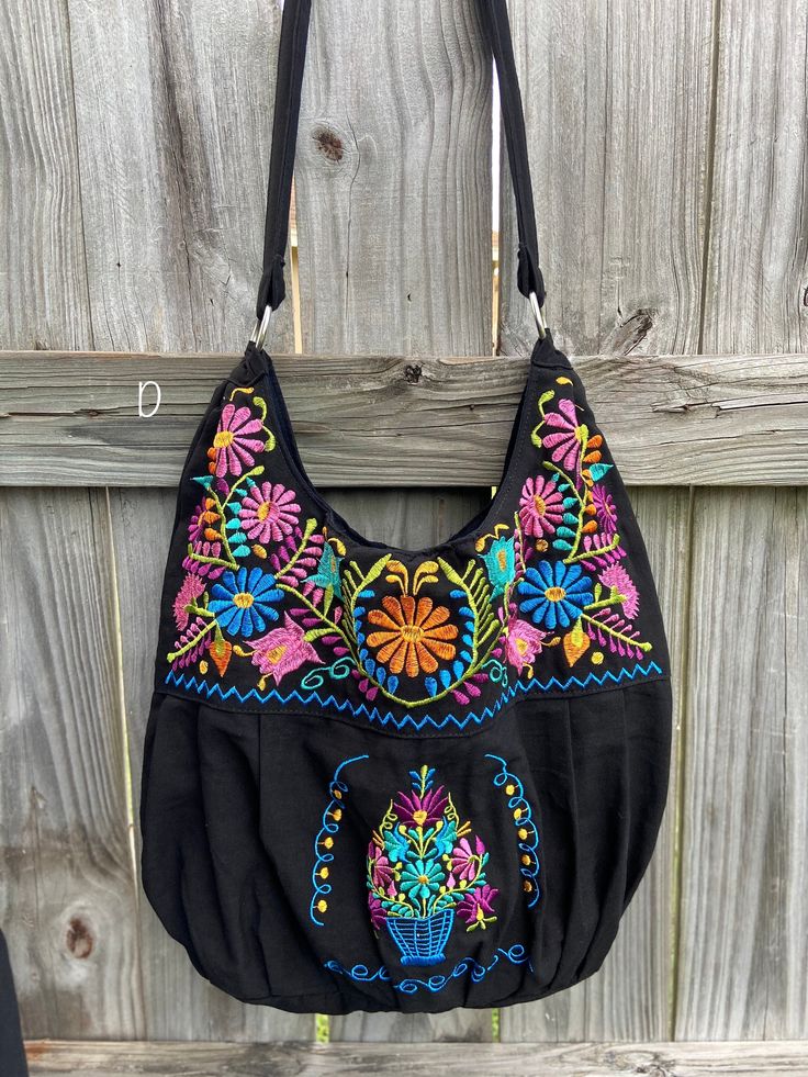 "Super Cute Floral Embroidered Bag from Puebla, Mexico Overview *Thread material * Cotton Fabric *approximate measurements: 13\" from bottom to zipper area & 15-16 with if expanded *handmade *Design colors may vary per purse as all are embroidered with unique colors * Closure is zipper or magnetic button - you can specify in notes section @ checkout which one you prefer * One pocket inside Care *hand wash only *delicate care *hang dry Please email me your questions before buying. All of my i Multicolor Floral Embroidered Shoulder Bag For Festivals, Floral Embroidered Shoulder Bag For Festivals, Festival Shoulder Bag With Multicolor Floral Embroidery, Festival Shoulder Bag With Floral Embroidery, Everyday Multicolor Embroidered Bag, Multicolor Embroidered Hobo Bag For Everyday Use, Embroidered Satchel Hobo Bag For Daily Use, Floral Embroidered Tote Shoulder Bag For Festival, Black Festival Bag With Floral Embroidery