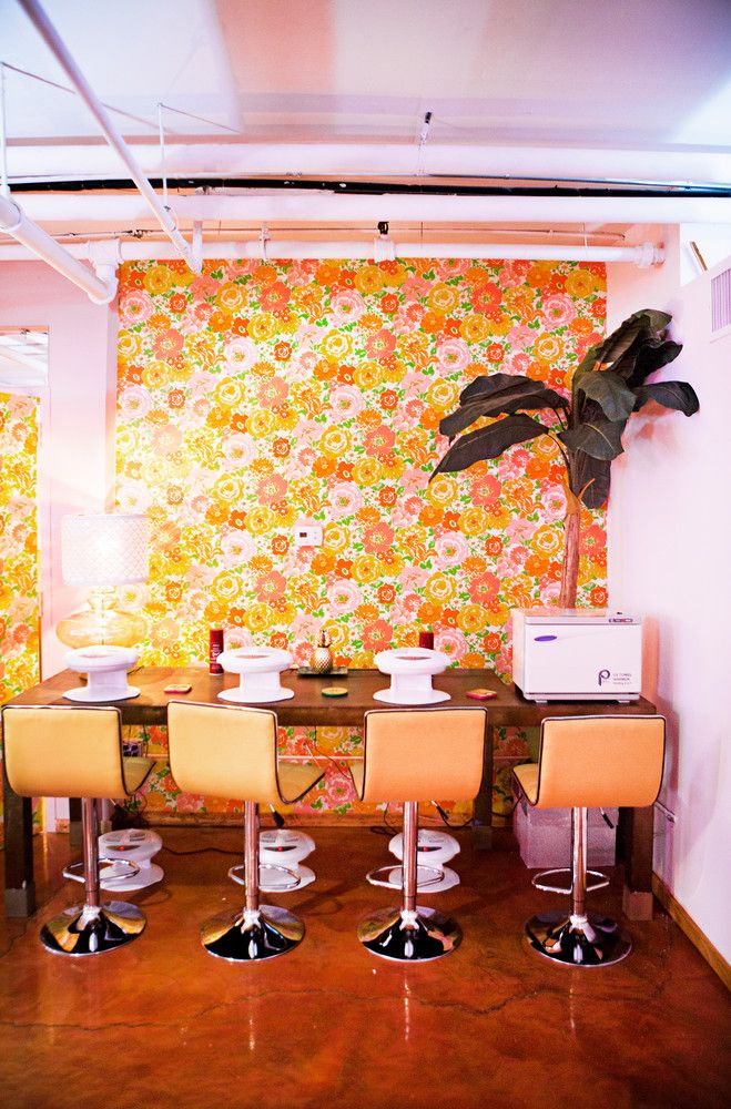 a dining room table with four chairs and a potted plant in the corner next to it