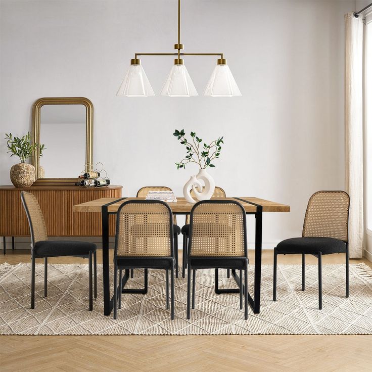 a dining room table with chairs and a mirror