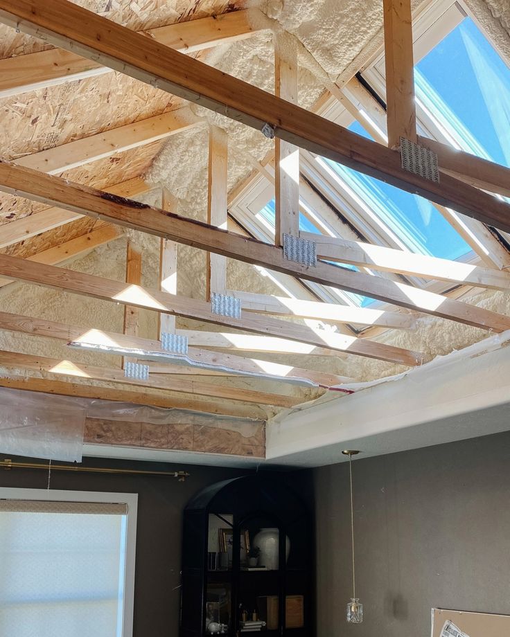 an unfinished room with wooden beams and windows on the ceiling is being built into the wall