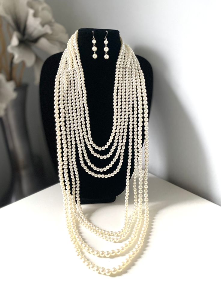 "Layered long white faux pearl necklace set for women Don't miss this opportunity to own this beautiful pearl necklace. This classic necklace is a timeless treasure and add a gorgeous glow to any outfit. Eight layers of pearls make this necklace truly statement piece! This multi strand necklace is made from high quality acrylic pearls, silver lobster clasp and adjustable chain. Measurement: First strands  25\"long+ext.(63 cm) Last strands 48\" long (122 cm) **I will pair this necklace with earri Cream Pearl Drop Jewelry, Pearl White Long Pearl Necklace In Elegant Style, Elegant White Pearl Chain Long Necklace, Elegant Pearl White Long Pearl Necklace, Elegant Pearl White Long Necklace, Multi-strand Pearl Chain Necklace For Party, Elegant Pearl White Multi-strand Necklace, Elegant Multi-strand Long Necklace, Elegant White Pearl Layered Necklace