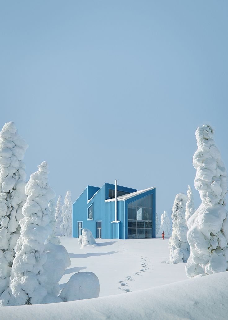 a blue building surrounded by snow covered trees