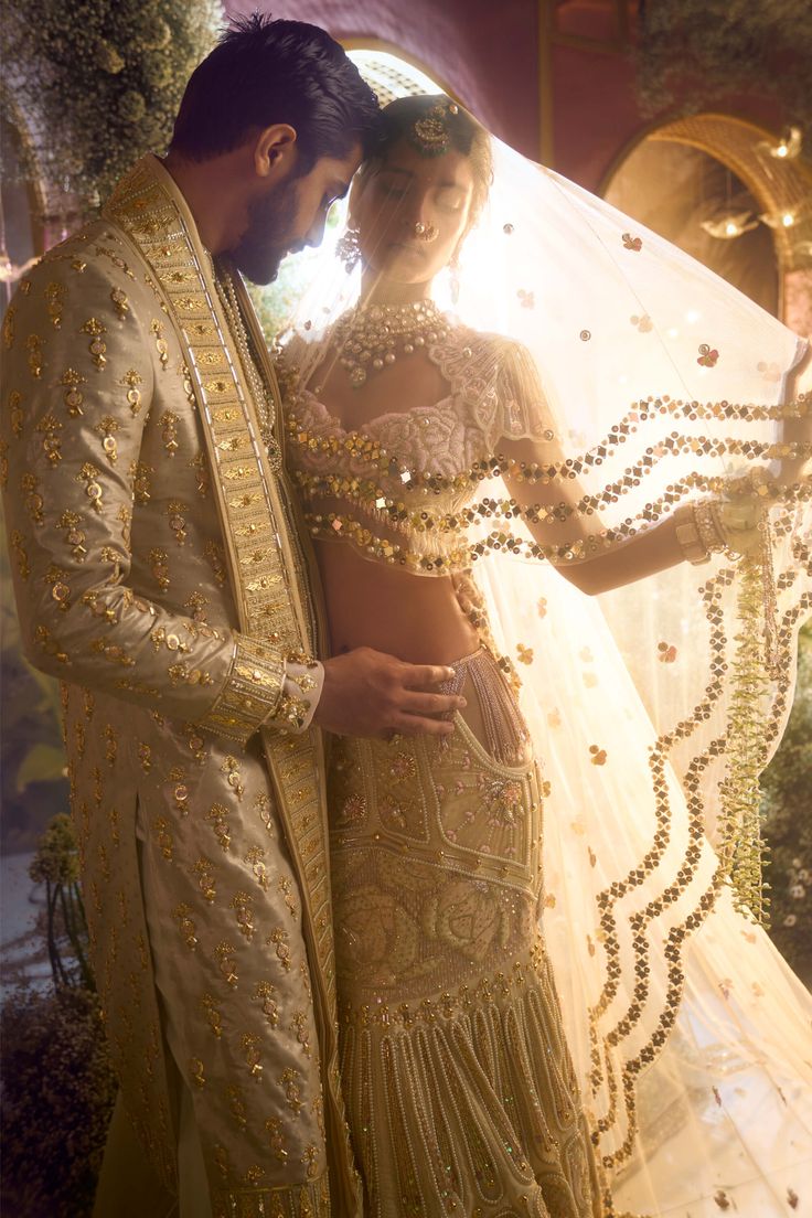 Unveil eternal elegance - our all ivory bridal lehenga set is a vision of grace and allure. Soft pink crystals and shimmering gold metals create a celestial beauty. Our signature ivory blouse with tassels adds a modern touch, while a soft ivory tulle head veil completes the enchantment. Step into the spotlight with this captivating ensemble, making your special day truly unforgettable. Ivory Bridal Lehenga, Head Veil, Blouse With Tassels, Papa Don't Preach, Asian Inspired Wedding, Fun Wedding Shoes, Tulle Embroidery, Ivory Blouse, Beaded Blouse