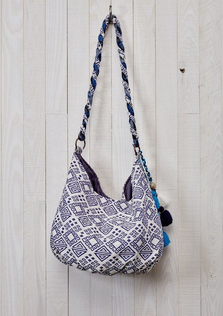 Add a bohemian touch to your ensemble with our mixed media hobo bag in hues of blue. Featuring a snap closure, a twisted strap, and a multi-tassel accent. A fashionable slouchy purse that's perfect for everyday use. Slouchy style bag Mixed media Single snap closure Twisted strap Multi tassel detail Beaded embellishments Dimensions: W: 19 in x H: 12 inStyle: DR-1929 Bohemian Bucket Bag Tote With Tassels, Bohemian Bucket Tote Bag With Tassels, Bohemian Tote Bucket Bag With Tassels, Bohemian Bucket Bag With Tassels For Daily Use, Blue Bohemian Bucket Bag For Travel, Bohemian Bucket Bag With Adjustable Strap For Everyday, Bohemian Summer Hobo Bag With Removable Pouch, Bohemian Hobo Bag With Removable Pouch For Summer, Blue Hobo Bag With Braided Handles