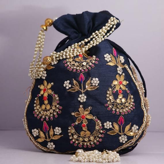 Material:Golden Lace Ribbon, Golden Metallic Wire, Motifs, ThreadColor: Navy Blue, Pink, Pistachio Green, Golden, Bronze, RedSize: 10" x 8"Designed with the heart, this beautiful Potli or batawa bag are eye catchy and made of premium material.Key Features:Embroidery art work. (gotta pati work).This potli is good match with both Indian and western outfits and are superb for wedding and festive parties.This would be best complement to your designer saree, lenhga or any other kind of dress.This is Gold Embroidered Pouch As Gift, Traditional Blue Bags For Festivals, Festive Bags With Gold Embroidery For Gift, Gold Embroidered Bags For Gifts, Gold Embroidered Pouch Bag For Festivals, Wedding Handheld Potli Bag, Wedding Handheld Potli Gift Bag, Traditional Bag With Gold Embroidery, Elegant Multicolor Embroidery Bag For Wedding