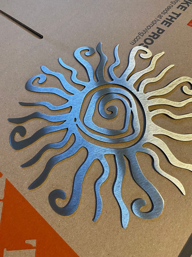 a close up of a metal object on top of a paper with an image of the sun