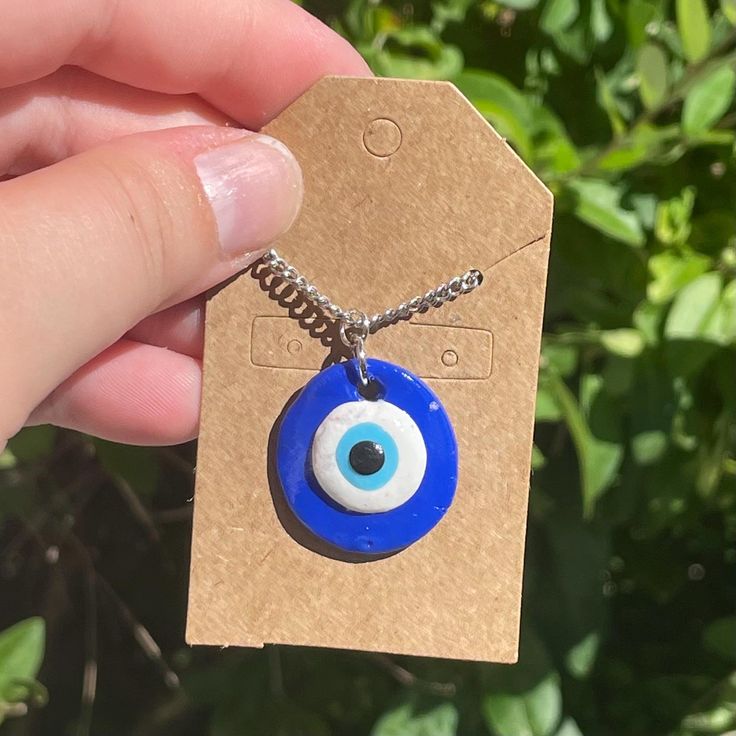 This Evil Eye Pendant Necklace is handmade with polymer clay and nickel free metal! Handmade Polymer Clay Round Pendant Jewelry, Handmade Blue Clay Jewelry, Handmade Blue Polymer Clay Necklaces, Handmade Adjustable Clay Jewelry, Blue Clay Jewelry For Gifts, Handmade Polymer Clay Round Pendant Necklace, Nickel-free Polymer Clay Necklace Gift, Handmade Round Polymer Clay Pendant Necklace, Everyday Handmade Blue Charm Necklaces