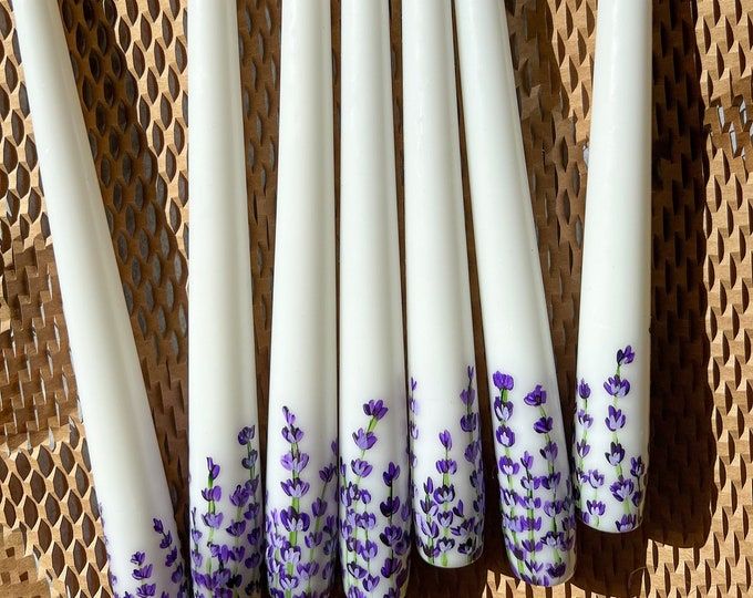 five white candles with purple flowers on them