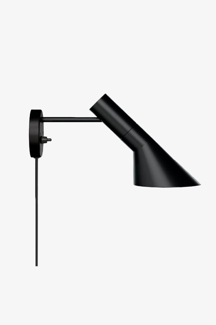 a black lamp on a white wall with a long arm and one light is attached to it